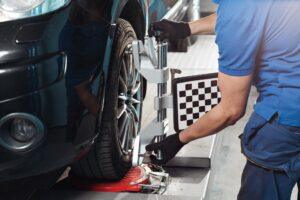 mechanic preforming wheel alignment on a car