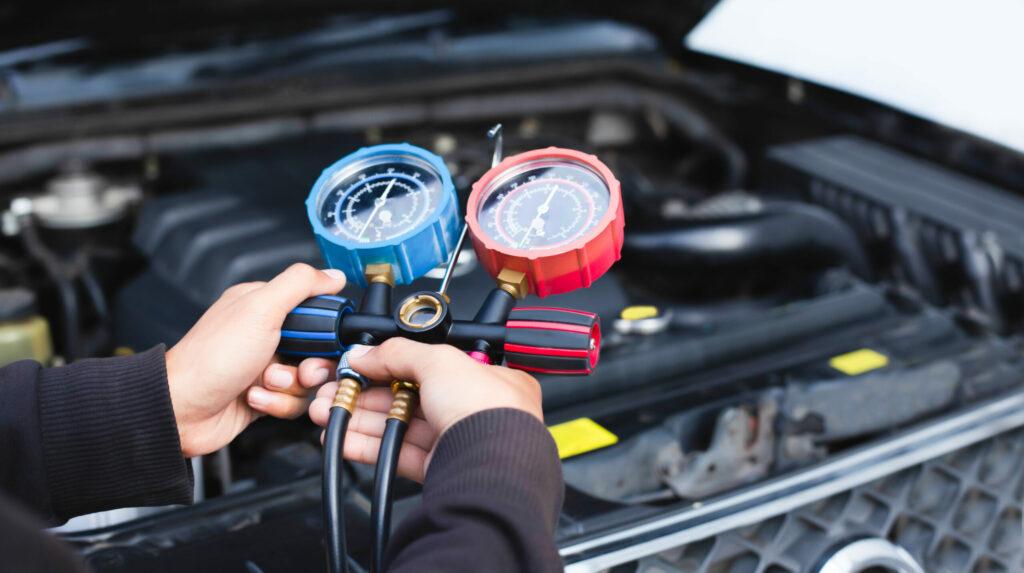 mechanic servicing car air conditioning system